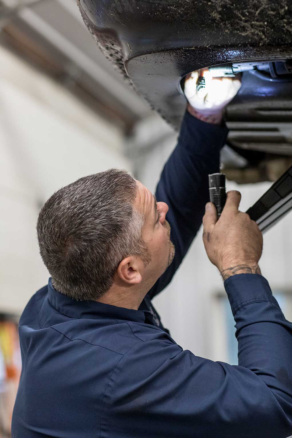 Technician inspecting undercarriage